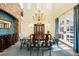Elegant dining room featuring a stunning chandelier, high ceilings, and exposed brick wall at 9151 E Harvard Ave, Denver, CO 80231