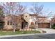 Beautiful stone home featuring a terracotta roof, arched entryway, and a well-manicured lawn at 9151 E Harvard Ave, Denver, CO 80231