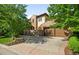 Charming stone home with a two-car garage and a beautifully paved driveway, complemented by landscaped garden beds at 9151 E Harvard Ave, Denver, CO 80231