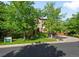 Stone home featuring mature trees, a lush lawn, and a driveway leading to an attached two-car garage at 9151 E Harvard Ave, Denver, CO 80231