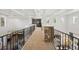 Carpeted hallway with decorative wrought iron railing, stone pillars and clear sightlines at 9151 E Harvard Ave, Denver, CO 80231