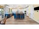 Bright kitchen boasts a blue island, wood floors, and modern appliances at 9151 E Harvard Ave, Denver, CO 80231