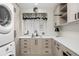 Well-organized laundry room featuring modern appliances, stylish cabinetry and ample storage at 9151 E Harvard Ave, Denver, CO 80231