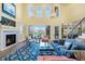 Open living room with fireplace, many windows with backyard views and a floral area rug at 9151 E Harvard Ave, Denver, CO 80231