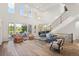 Bright living room boasting a soaring ceiling, large windows, and a staircase with decorative wrought iron railings at 9151 E Harvard Ave, Denver, CO 80231