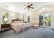 Spacious primary bedroom with vaulted ceilings, patterned carpet, and French doors leading to the backyard patio at 9151 E Harvard Ave, Denver, CO 80231