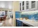 Elegant wet bar with wine storage, glass racks, and stainless steel sink at 9151 E Harvard Ave, Denver, CO 80231
