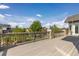 An outdoor deck area features lovely stone supports and a metal railing system overlooking the backyard at 1199 Links Ct, Erie, CO 80516