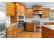 Close up of kitchen with wood cabinets, stainless steel appliances, tile backsplash, and granite countertops at 1199 Links Ct, Erie, CO 80516