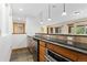Basement kitchenette with stainless steel appliances and dark granite countertops at 1199 Links Ct, Erie, CO 80516