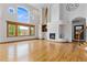 Bright, open living room features tall windows, hardwood floors, and a cozy fireplace at 1199 Links Ct, Erie, CO 80516