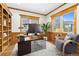 Home office with wood trim, built-in shelves, large desk, plush chair, and ample natural light at 1199 Links Ct, Erie, CO 80516