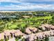 Expansive aerial view of golf course community featuring lush green fairways, elegant homes, and serene water features at 7887 Vallagio Ln, Englewood, CO 80112