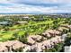 Breathtaking aerial view of golf course community with manicured green spaces, diverse homes, and tranquil streets at 7887 Vallagio Ln, Englewood, CO 80112