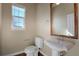 A neutral-toned powder room featuring a pedestal sink, wood-look floors, and a window at 7887 Vallagio Ln, Englewood, CO 80112