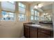 Bathroom featuring a large mirror, a vanity with dark wood cabinets, and natural light at 7887 Vallagio Ln, Englewood, CO 80112