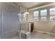 Bathroom featuring a glass-enclosed shower, neutral tiling, and a vanity with dark wood cabinets at 7887 Vallagio Ln, Englewood, CO 80112