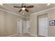 Bedroom features a ceiling fan, neutral walls, carpet, and white doors and trim at 7887 Vallagio Ln, Englewood, CO 80112