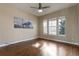 Bedroom with hardwood floors showcases three windows and mountain-themed artwork at 7887 Vallagio Ln, Englewood, CO 80112