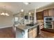 Open concept kitchen with stone countertops and an island cooktop at 7887 Vallagio Ln, Englewood, CO 80112