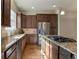 A kitchen with stainless steel appliances, stone countertops, and wood floors at 7887 Vallagio Ln, Englewood, CO 80112
