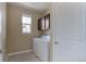 A functional laundry room with a window and a white washer and dryer set at 7887 Vallagio Ln, Englewood, CO 80112