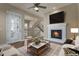 Inviting living room with a cozy fireplace, modern ceiling fan, and easy access to the outside at 7887 Vallagio Ln, Englewood, CO 80112