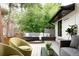 A deck with green chairs and a wooden hot tub surrounded by lush trees in a private outdoor oasis at 62 Jasmine St, Denver, CO 80220