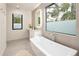 Modern bathroom featuring a soaking tub, a vanity, and large windows at 62 Jasmine St, Denver, CO 80220