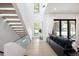 Bright foyer with high ceilings, staircase with glass railing, and wall of windows at 62 Jasmine St, Denver, CO 80220