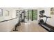 Spacious home gym with weight machine, treadmill, and large windows offering natural light and treetop views at 62 Jasmine St, Denver, CO 80220