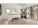 Bright home gym featuring a weight machine, bench, and large windows offering natural light and treetop views at 62 Jasmine St, Denver, CO 80220
