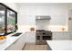 Bright kitchen featuring stainless steel appliances, white cabinets and hardwood floors at 62 Jasmine St, Denver, CO 80220