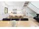 Modern kitchen with stainless steel appliances, island with bar seating, and open staircase at 62 Jasmine St, Denver, CO 80220