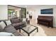 Open living area with grand piano, comfortable seating, and view to outdoor dining at 62 Jasmine St, Denver, CO 80220