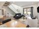 Open concept living area with modern staircase, hardwood floors, and access to outdoor patio at 62 Jasmine St, Denver, CO 80220