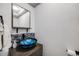 Modern half bathroom with blue glass bowl sink and tiled wall at 12956 W Virginia Ave, Lakewood, CO 80228