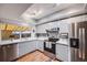 Bright kitchen with stainless steel appliances and wood floors at 12956 W Virginia Ave, Lakewood, CO 80228