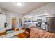 Bright kitchen with stainless steel appliances, wood floors, and dining area at 12956 W Virginia Ave, Lakewood, CO 80228