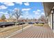 Inviting front porch with wood flooring and metal railings overlooking a quiet residential street at 1436 S Yates St, Denver, CO 80219