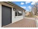 Close-up of the front porch with wood floor, contemporary lighting, and modern front door at 1436 S Yates St, Denver, CO 80219