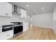 Bright kitchen features stainless steel appliances, white cabinets, and ample counter space at 1436 S Yates St, Denver, CO 80219