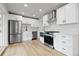 Updated kitchen with stainless steel appliances, white cabinets, and modern countertops at 1436 S Yates St, Denver, CO 80219