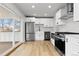 Bright kitchen features white cabinets, stainless steel appliances, and sliding doors to outdoor area at 1436 S Yates St, Denver, CO 80219