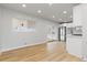 Open living space with wood floors connecting to a modern kitchen and a sliding glass door at 1436 S Yates St, Denver, CO 80219