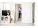 Well-lit bedroom with closet, TV, and a full-length mirror at 5025 Central Park Blvd, Denver, CO 80238