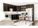 Bright kitchen with dark wood cabinetry, stainless steel appliances, and eat-in dining area at 5025 Central Park Blvd, Denver, CO 80238