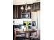 Bright kitchen with dark wood cabinetry, stainless steel appliances, and eat-in dining area at 5025 Central Park Blvd, Denver, CO 80238