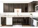 Modern kitchen featuring dark cabinets, light countertops, and stainless steel appliances at 5025 Central Park Blvd, Denver, CO 80238