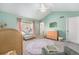 Inviting Bedroom with mint walls, neutral carpet, charming decor, and a cozy seating area at 8381 E 29Th Ave, Denver, CO 80238